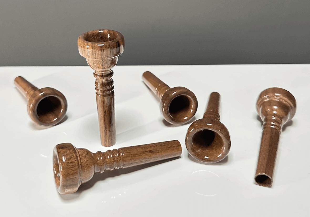 Holzmundstücke für Alphörner elegant auf weißem Tisch, ideal für naturverbundene Klangqualität bei NATURINSTRUMENTE Heimatklang.