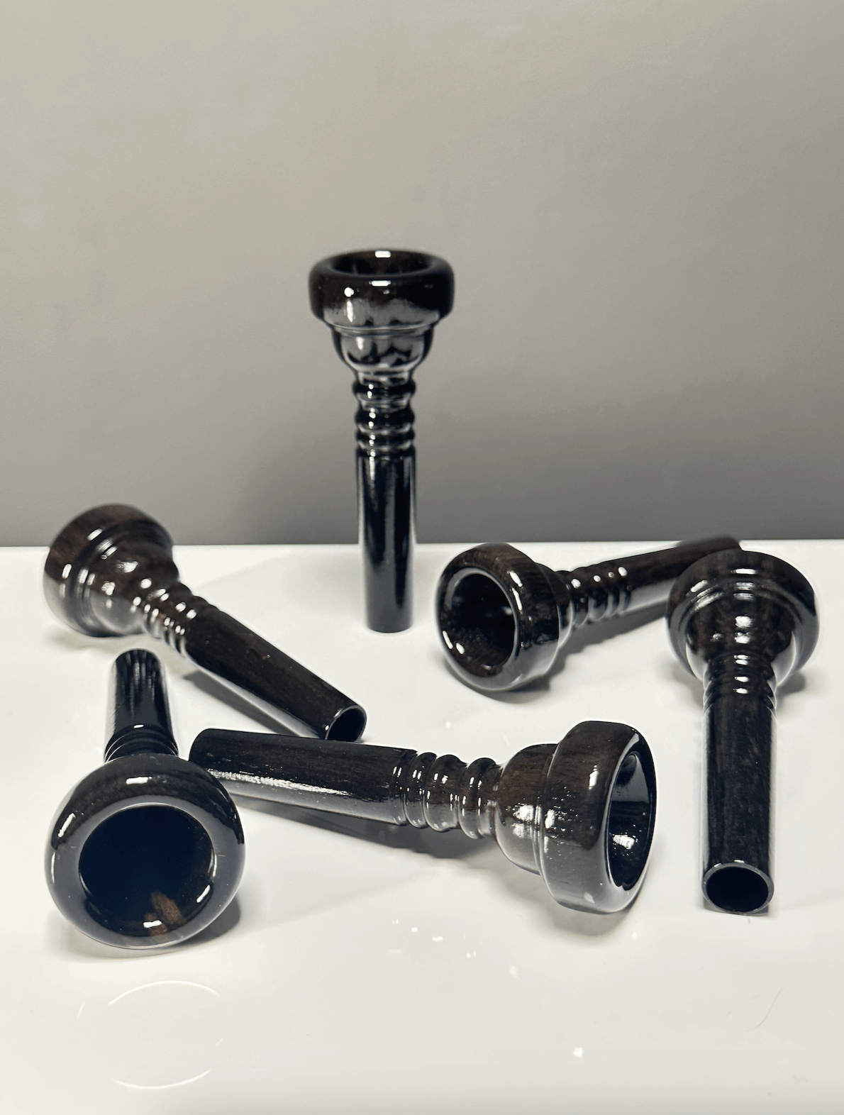 Hochwertige Holzmundstücke für Alphörner auf weißem Hintergrund, perfekt für traditionellen Heimatklang und Naturinstrumente.