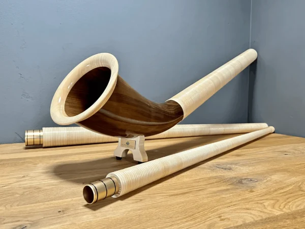 Hochwertiges Alphorn aus Holz mit erlesenen Mundstücken, perfekt für traditionelle Klänge in Alpenlandschaften.