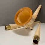 Elegantes Alphorn und Mundstücke aus hellem Holz, präsentiert auf einer Webseite für hochwertige Naturinstrumente.