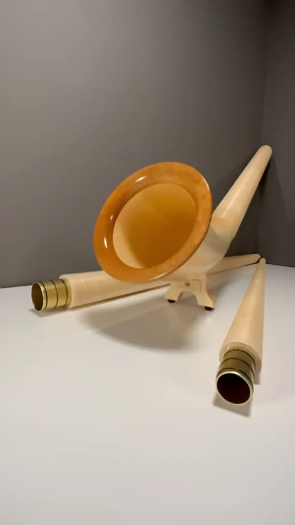 Elegantes Alphorn und Mundstücke aus hellem Holz, präsentiert auf einer Webseite für hochwertige Naturinstrumente.
