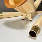 Hochwertige Alphörner und präzise Holzmundstücke von NATURINSTRUMENTE Heimatklang auf weißem Hintergrund, elegantes Design.