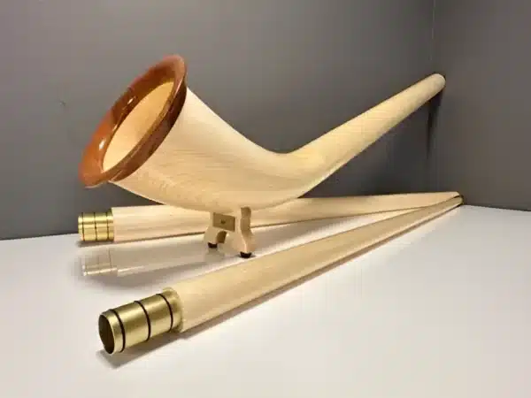 Alphorn mit edlen Holzmundstücken auf weißem Hintergrund, präsentiert von NATURINSTRUMENTE Heimatklang.