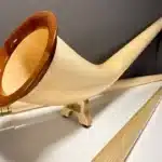 Alpenhorn aus hellem Holz mit edlem Mundstück, präsentiert für NATURINSTRUMENTE Heimatklang auf einem weißen Hintergrund.