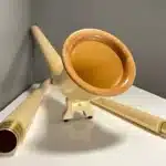 Alphorn mit hochwertigen Holzmundstücken, präsentiert auf einem Tisch, ideal für traditionelle Klänge aus den Alpen.