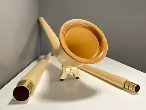Alphorn mit hochwertigen Holzmundstücken, präsentiert auf einem Tisch, ideal für traditionelle Klänge aus den Alpen.