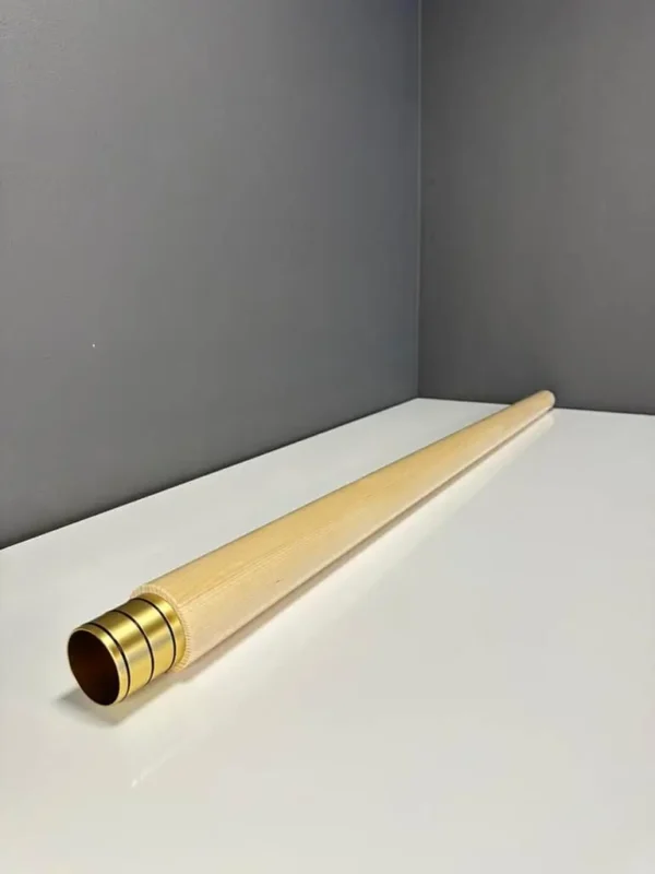 Hochwertiges Alphorn-Holzmundstück auf weißem Tisch vor grauer Wand. Perfekt für NATURINSTRUMENTE Heimatklang.