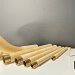 Set aus hochwertigen Alphorn-Segmenten und Mundstücken auf einem Tisch, präsentiert von NATURINSTRUMENTE Heimatklang.