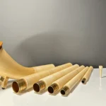 Alphorn in Einzelteilen mit dazugehörigen Holzmundstücken auf einem Tisch, bereit für den Zusammenbau, Heimatklang NATURINSTRUMENTE.