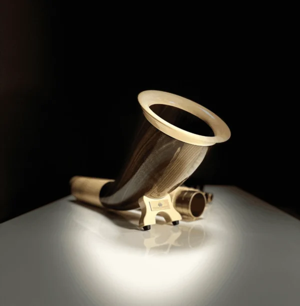 Elegantes Alphorn-Mundstück aus Holz auf glänzendem Tisch, Fokus auf Handwerkskunst und natürliche Materialien von Heimatklang.
