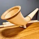 Hochwertiges Alphorn mit sorgfältig verarbeitetem Holzmundstück auf Holztisch, präsentiert von NATURINSTRUMENTE Heimatklang.