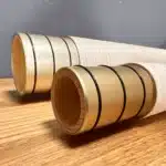Detailaufnahme von zwei hochwertigen Alphorn-Mundstücken aus Holz, edel verarbeitet, auf Holztisch liegend.