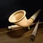 Hochwertiges Alphorn aus Holz, präsentiert auf einem Holztisch, ideal für traditionelle Klänge.