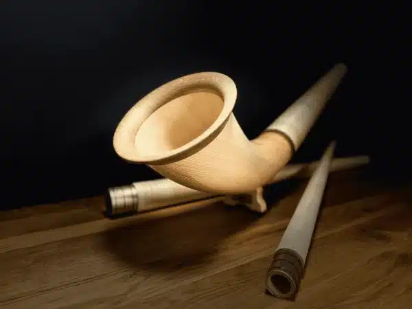 Hochwertiges Alphorn aus Holz, präsentiert auf einem Holztisch, ideal für traditionelle Klänge.