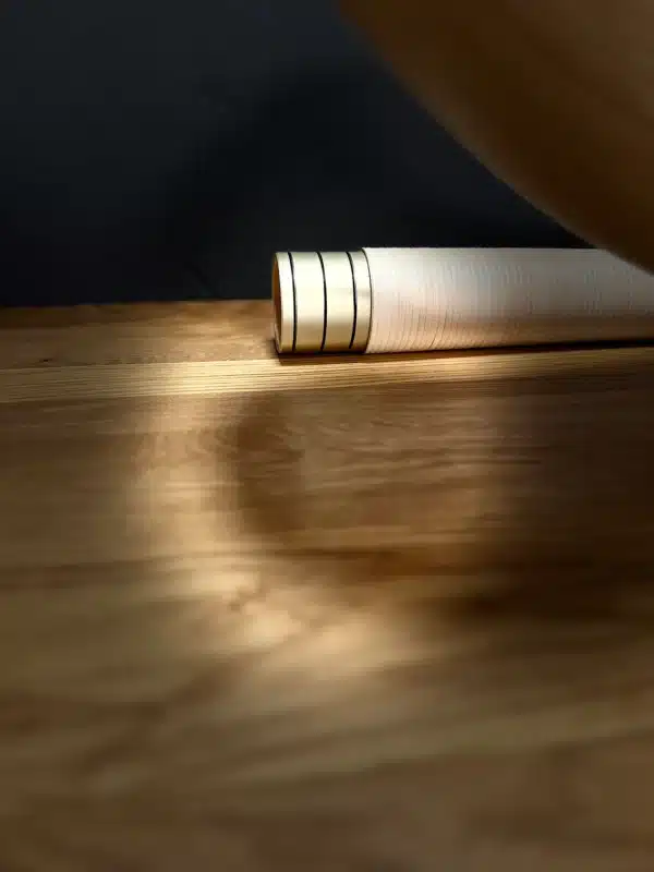 Hochwertiges Holzkorpus eines Alphorns auf Holzoberfläche, betont durch sanftes Licht. Ideal für Naturinstrumente und Klangvielfalt.
