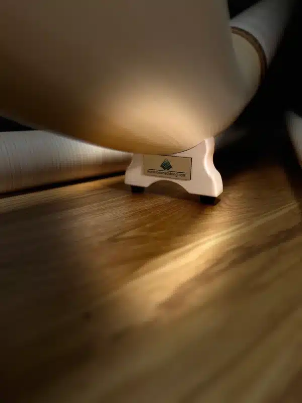 Hochwertiges Alphorn auf Holzständer in warmem Licht, Heimatklang-Logo sichtbar, Symbol für traditionelle Handwerkskunst.