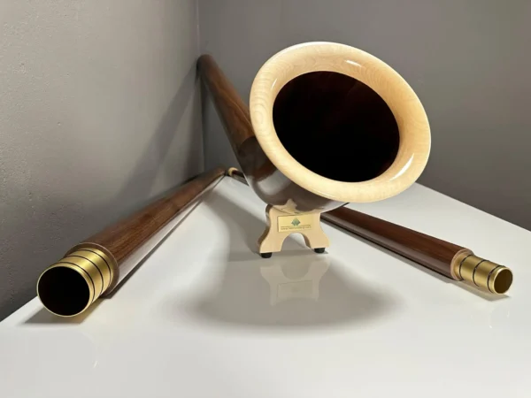 Alphorn aus edlem Holz mit detailreichen Mundstücken, präsentiert auf weißem Hintergrund. Hochwertige Handwerkskunst.