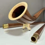 Elegante Alphörner mit edlen Holzmundstücken auf Hochglanzoberfläche, präsentiert von NATURINSTRUMENTE Heimatklang.