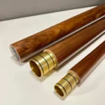 Drei edle Alphornteile mit goldenen Mundstücken auf weißem Hintergrund, ideal für traditionelle Naturinstrumente.
