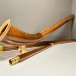 Alphorn aus edlem Holz mit präzisen Mundstücken, präsentiert auf einer glatten Oberfläche, ideal für NATURINSTRUMENTE Heimatklang.