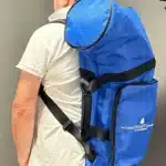 Person trägt blauen Rucksack von NATURINSTRUMENTE Heimatklang, designed für den sicheren Transport von Alphörnern.