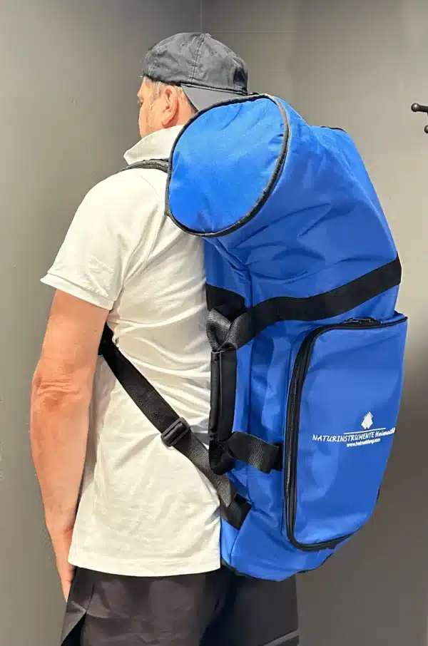 Person trägt blauen Rucksack von NATURINSTRUMENTE Heimatklang, designed für den sicheren Transport von Alphörnern.