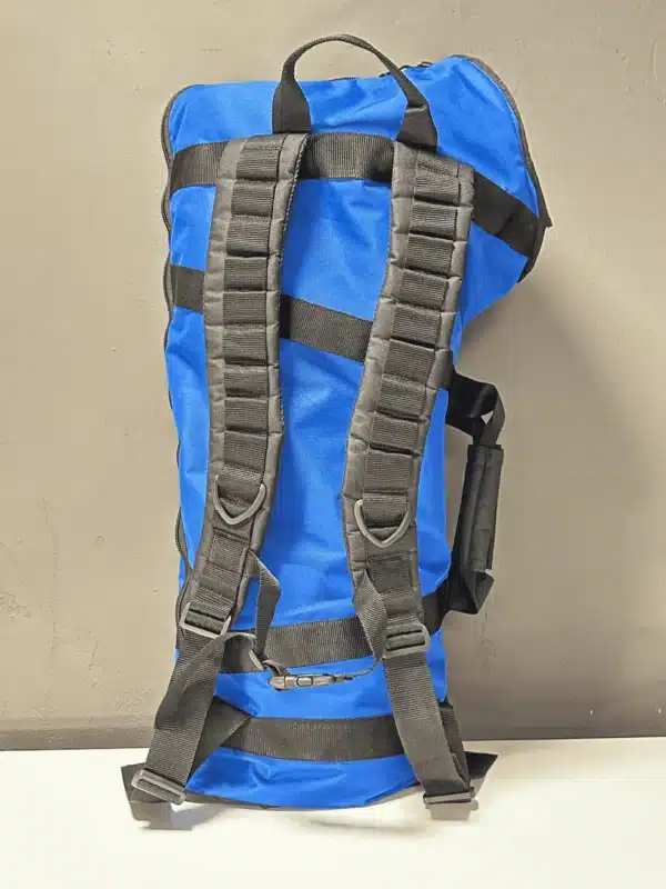 Blauer Rucksack mit schwarzen Trägern an der Wand hängend, ideal für den Transport von Naturinstrumenten wie Alphörnern.