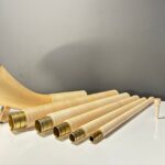 Hochwertige Alphornteile und Holzmundstück auf einem Tisch, ideal für Naturinstrumente-Enthusiasten bei Heimatklang.