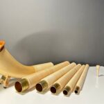 Alphorn aus mehreren Teilen mit Holzmundstück, hochwertig gefertigt, präsentiert auf einem Tisch, ideal für Naturinstrumente.