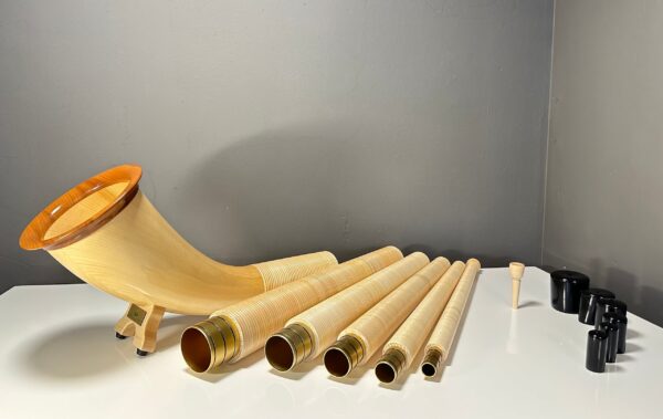 Alphorn aus mehreren Teilen mit Holzmundstück, hochwertig gefertigt, präsentiert auf einem Tisch, ideal für Naturinstrumente.