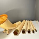Alphorn aus Holz in Einzelteilen, inklusive Mundstück, auf einem Tisch präsentiert. Ideal für NATURINSTRUMENTE Heimatklang.