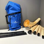 Alphorn mit Holzmundstück und Tragetasche, präsentiert auf Tisch für Naturinstrumente von Heimatklang.