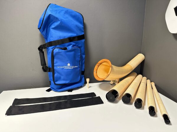 Alphorn mit Holzmundstück und Tragetasche, präsentiert auf Tisch für Naturinstrumente von Heimatklang.