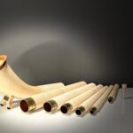Hochwertiges Alphorn mit auswechselbaren Holzteilen und Mundstücken auf einem Tisch bei Heimklang Naturinstrumente.