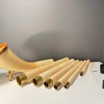 Handgefertigtes Alphorn mit hochwertigem Holzmundstück, präsentiert auf einem Tisch, unterstreicht natürliche Musikalität.