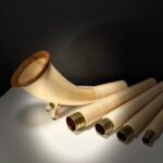 Exklusives Alphorn aus Holz mit detailreichen Mundstücken, präsentiert auf einer Webseite über hochwertige Naturinstrumente.