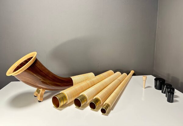 Alphorn mit abnehmbaren Holzmundstücken und Segmenten, präsentiert auf einem Tisch. Perfekte Wahl für Naturinstrumente.