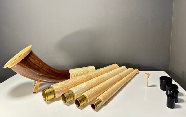 Alphorn mit Holzmundstück und austauschbaren Segmenten für individuellen Klang auf weißer Oberfläche.