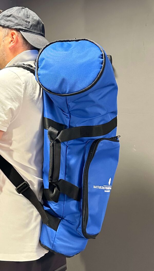 Person trägt einen blauen NATURINSTRUMENTE-Rucksack, ideal für den sicheren Transport von Alphornteilen und Zubehör.