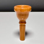 Holzmundstück für Alphörner, handgefertigt aus edlem Holz, glänzend poliert, für optimalen Klang und Spielkomfort.