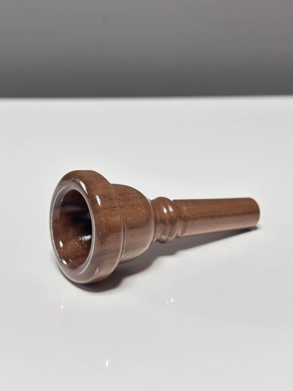 Hochwertiges Holzmundstück für Alphorn, handgefertigt von Heimatklang, präsentiert auf einer glatten, weißen Oberfläche.