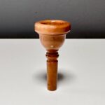 Elegantes Holzmundstück für Alphörner vor grauem Hintergrund, perfekt für Naturinstrumente-Enthusiasten.