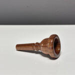 Handgefertigtes Holzmundstück für Alphorn, präsentiert auf einer glatten Fläche, ideal für NATURINSTRUMENTE-Enthusiasten.
