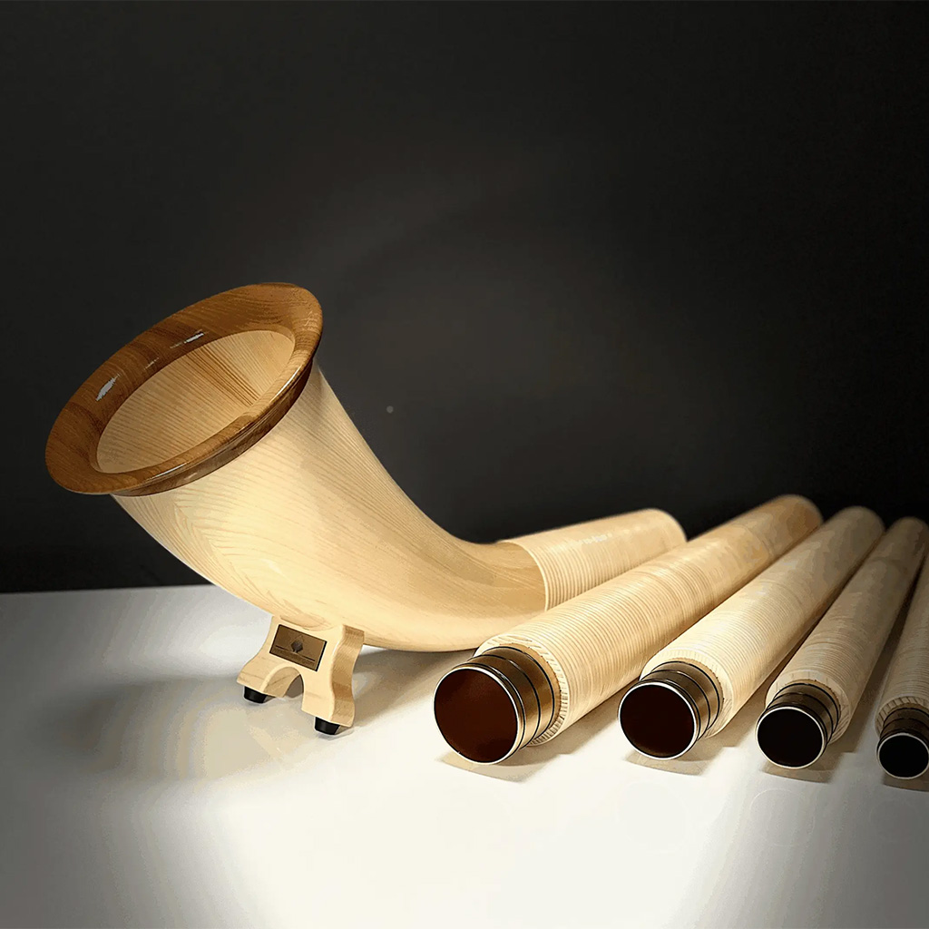 Elegant alphorns made of light wood with interchangeable mouthpieces, presented on a stylish, dark background.