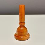 Holzmundstück für Alphorn, gefertigt aus hochwertigem Material, präsentiert sich auf einer weißen Oberfläche.
