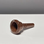 Edles Holzmundstück für Alphorn auf weißem Hintergrund präsentiert, betont Handwerkskunst und Qualität der NATURINSTRUMENTE.