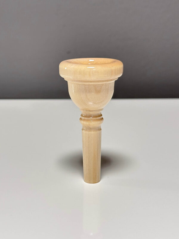 Hochwertiges Holzmundstück für Alphorn auf weißem Tisch, handgefertigt für besten Klang bei NATURINSTRUMENTE Heimatklang.