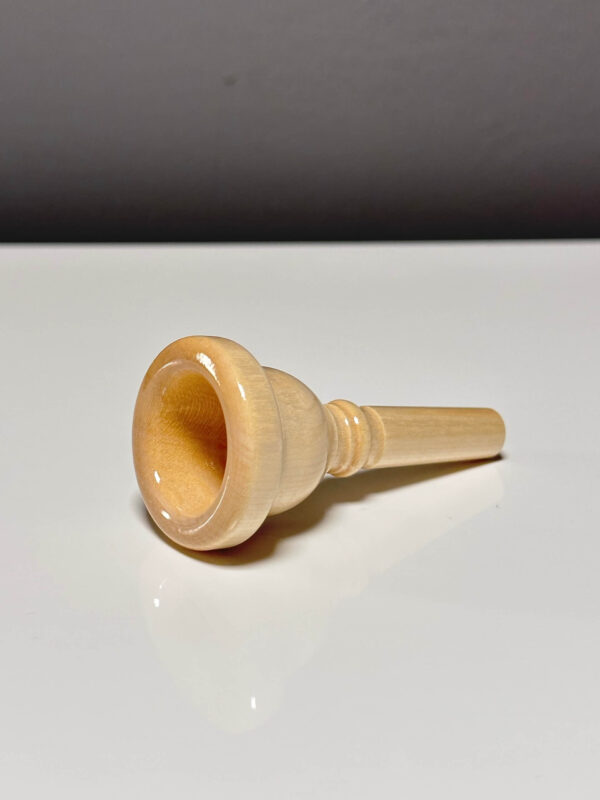 Hochwertiges Holzmundstück für Alphorn auf glänzendem Tisch, ideal für Naturinstrumente-Enthusiasten bei Heimatklang.