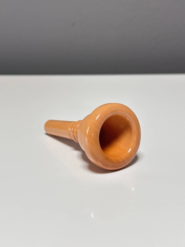 Hochwertiges Holzmundstück für Alphörner auf einem Tisch, ideal für authentischen Klang und traditionelles Musikerlebnis.