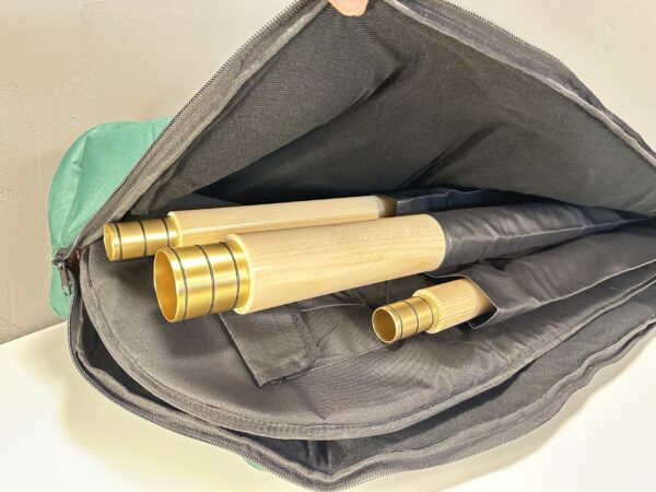 Alphornteile in einer Tasche mit präzisen Holzmundstücken, ideal für musikalischen Genuss in der Natur.